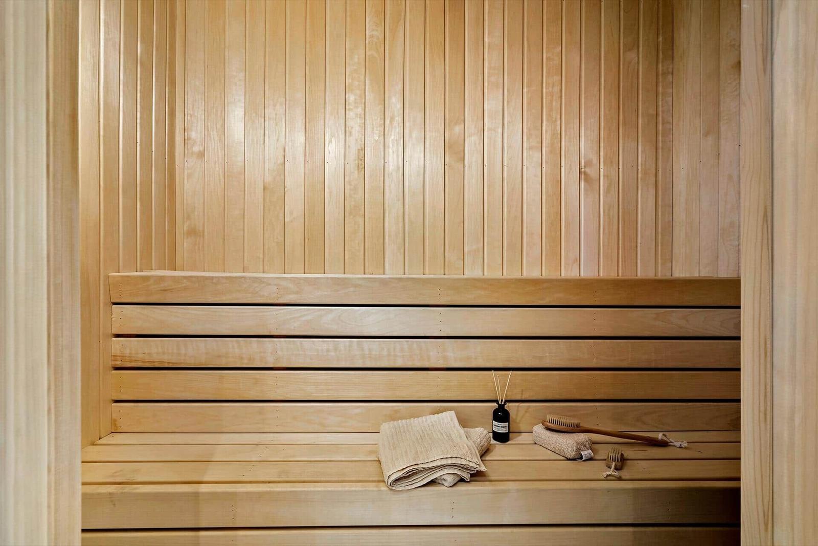 Sauna with wooden bench and towel