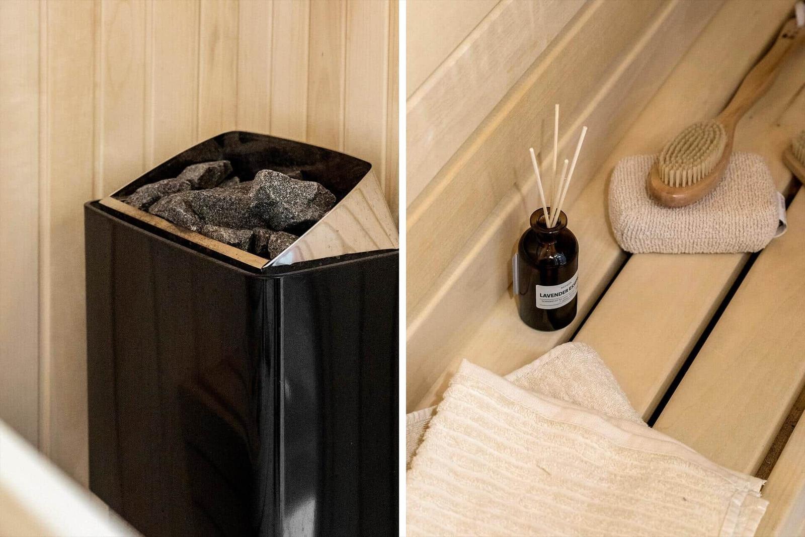 Sauna with stone heater and reed diffuser on wooden bench.