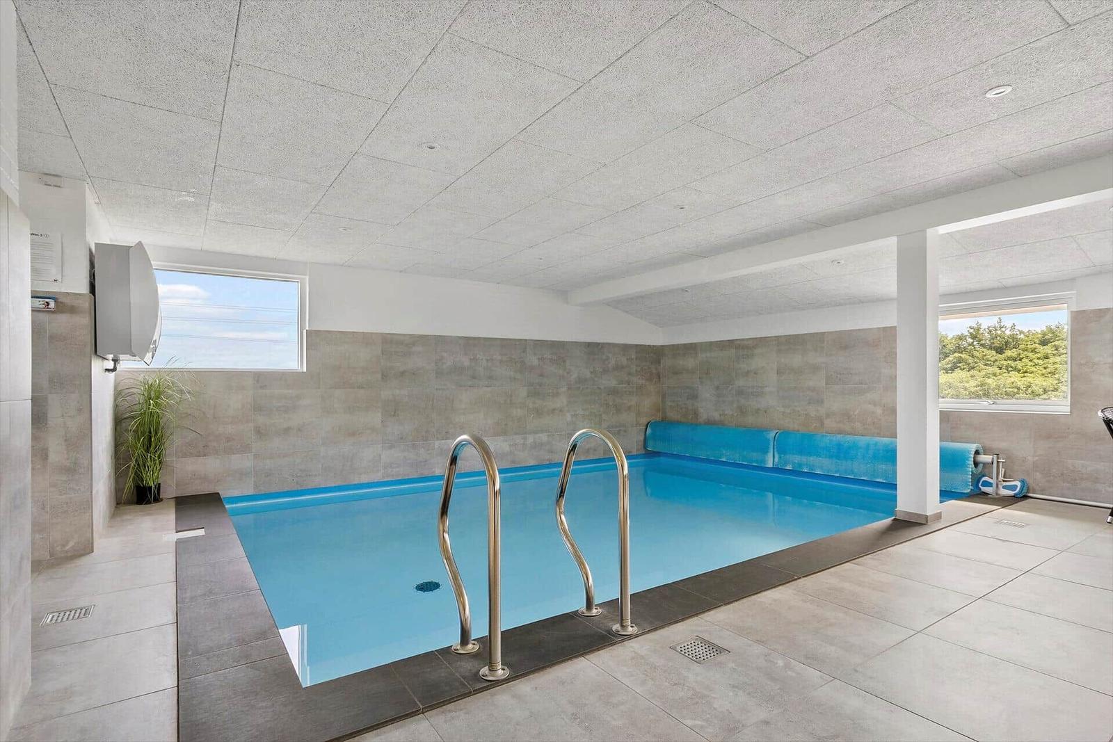 Indoor pool with blue water and metal ladders