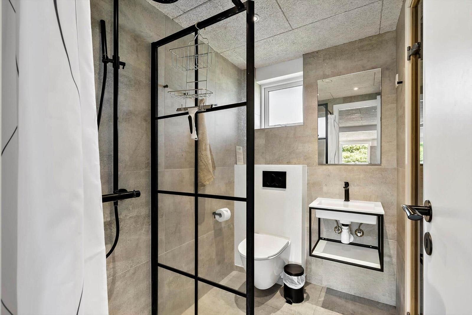 Bathroom with shower, toilet, and sink.