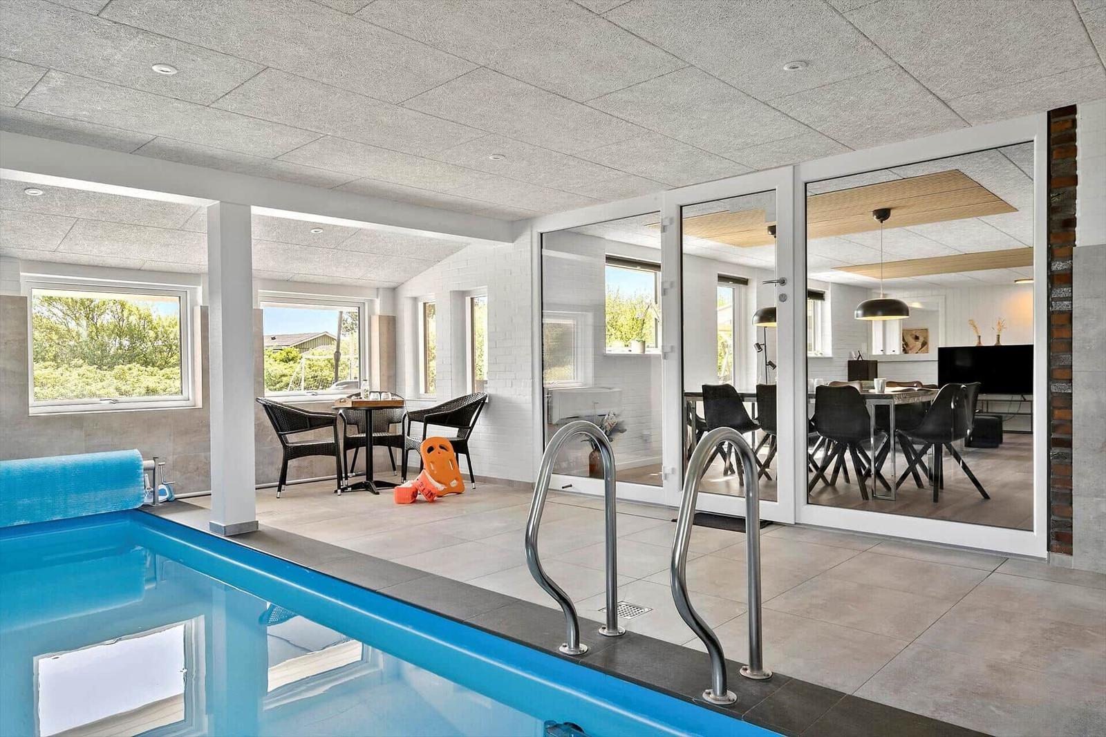Indoor pool with view of dining room and terrace.