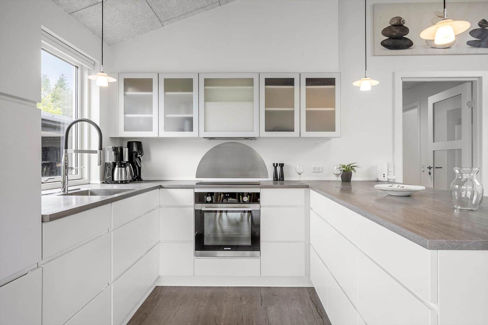 Modern kitchen with white cabinets and gray worktop.
