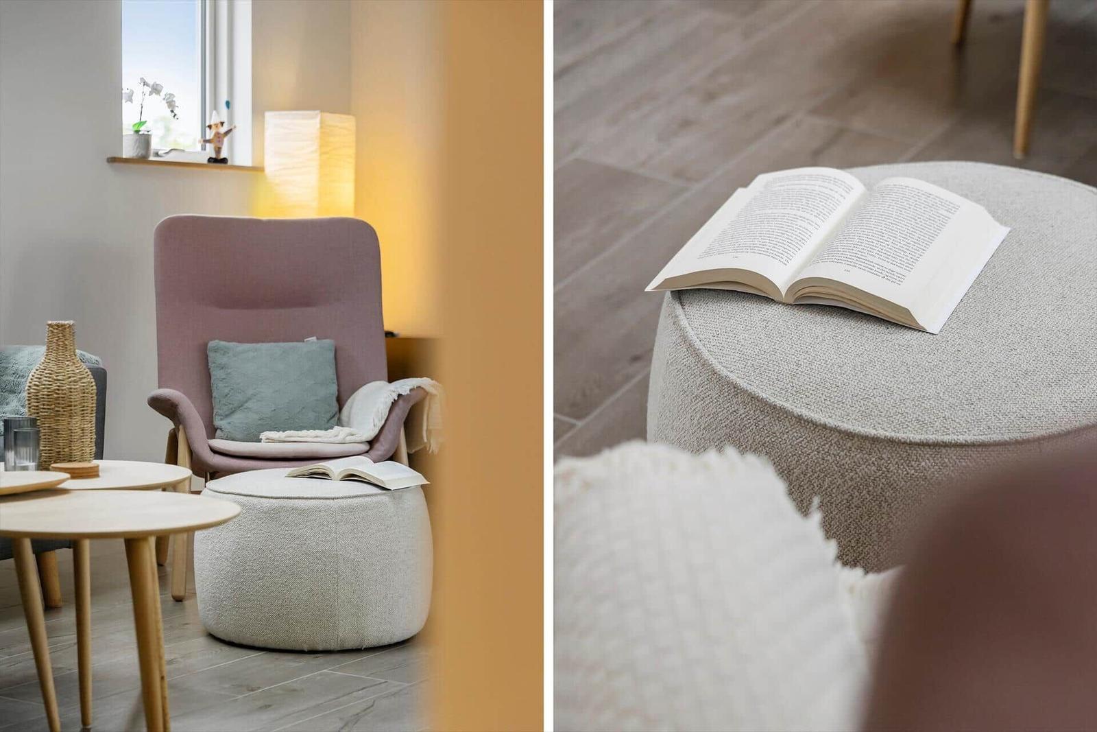 An armchair with cushions and a footstool with a book.