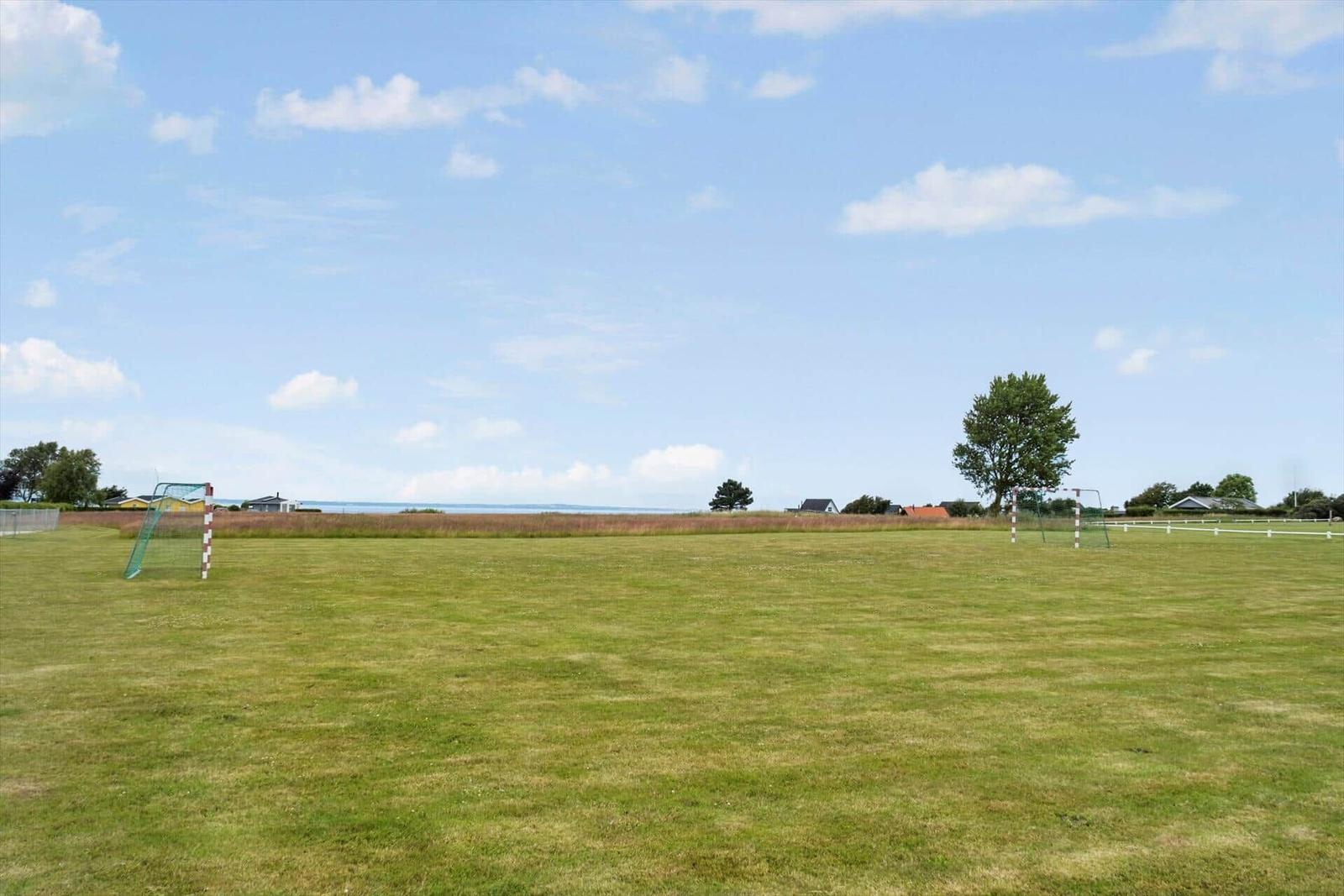 Grünes Feld mit Fußballtor und Blick auf das Meer.