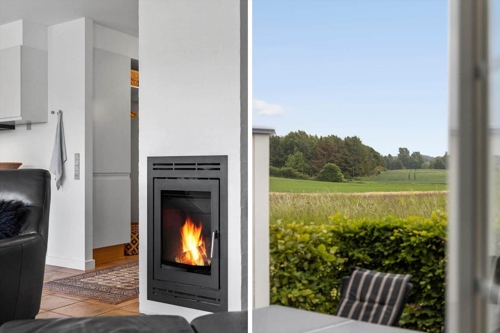 Kamin im Wohnbereich mit Blick auf grünes Feld und Wald.