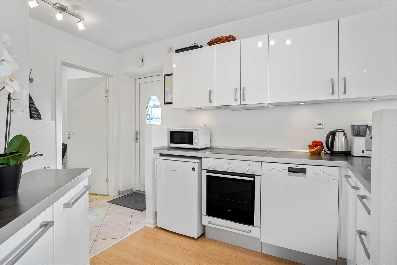 Kitchen with white cabinets, stove, dishwasher, and refrigerator.
