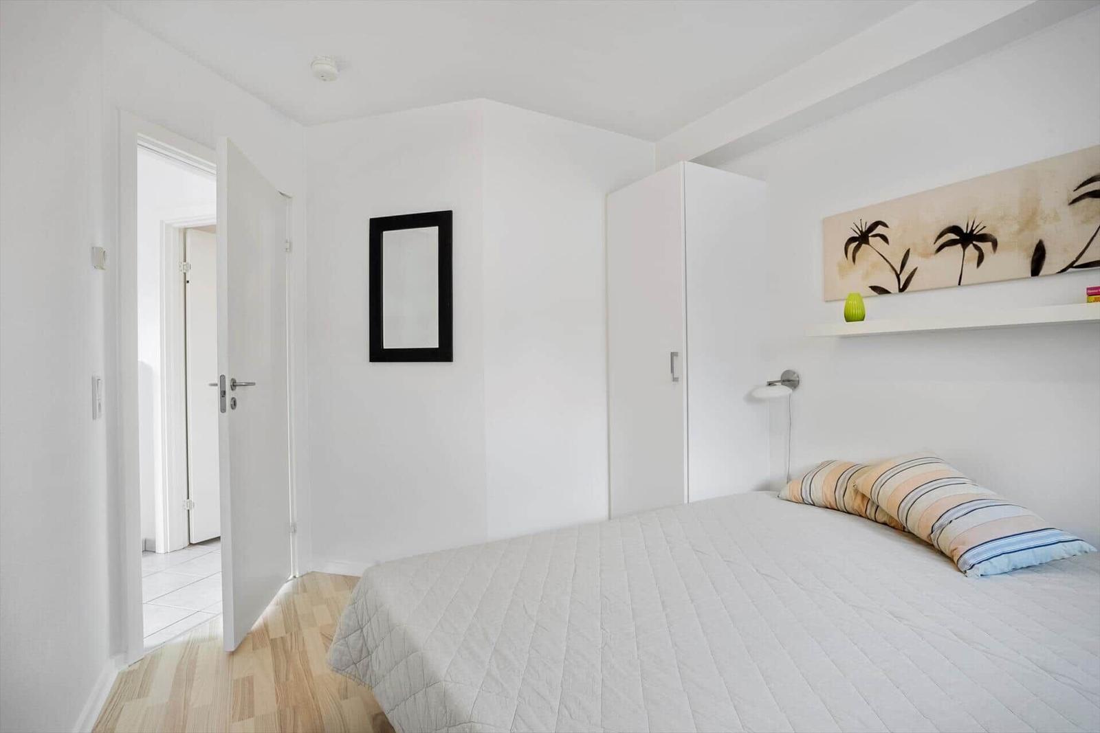 Bedroom with bed, wardrobe, and wall art