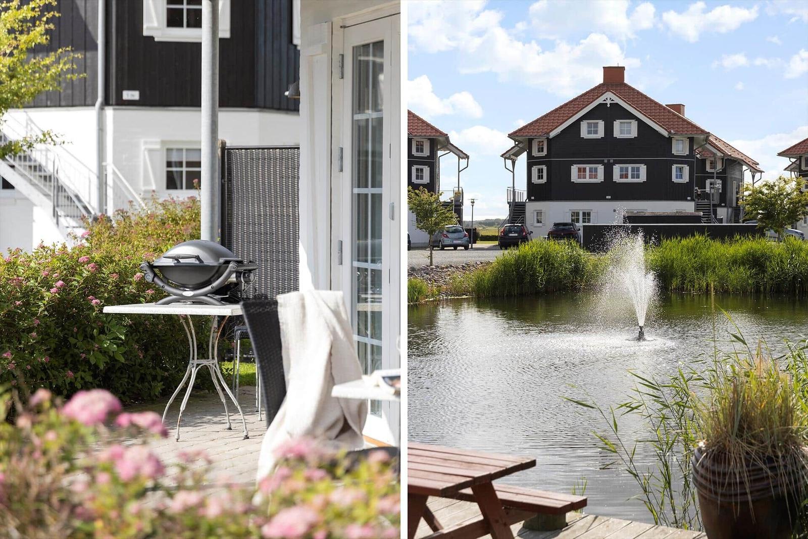 Terrace with grill and view of a pond with fountain.