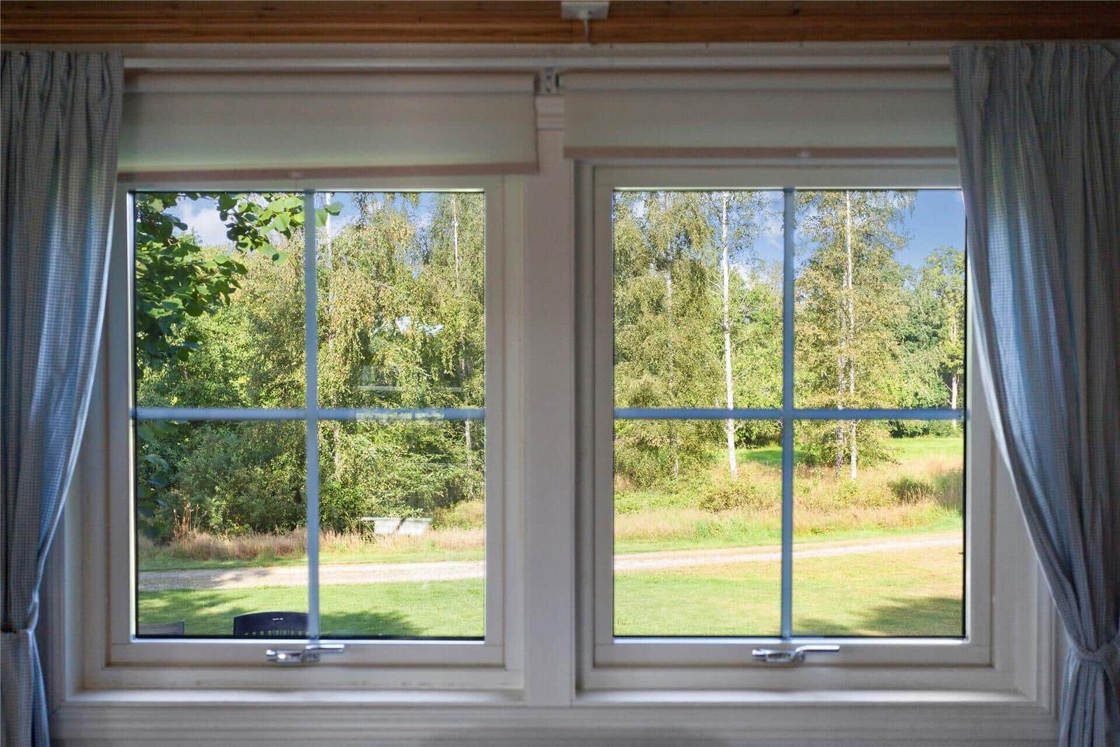 Two windows with view of green meadows and trees.