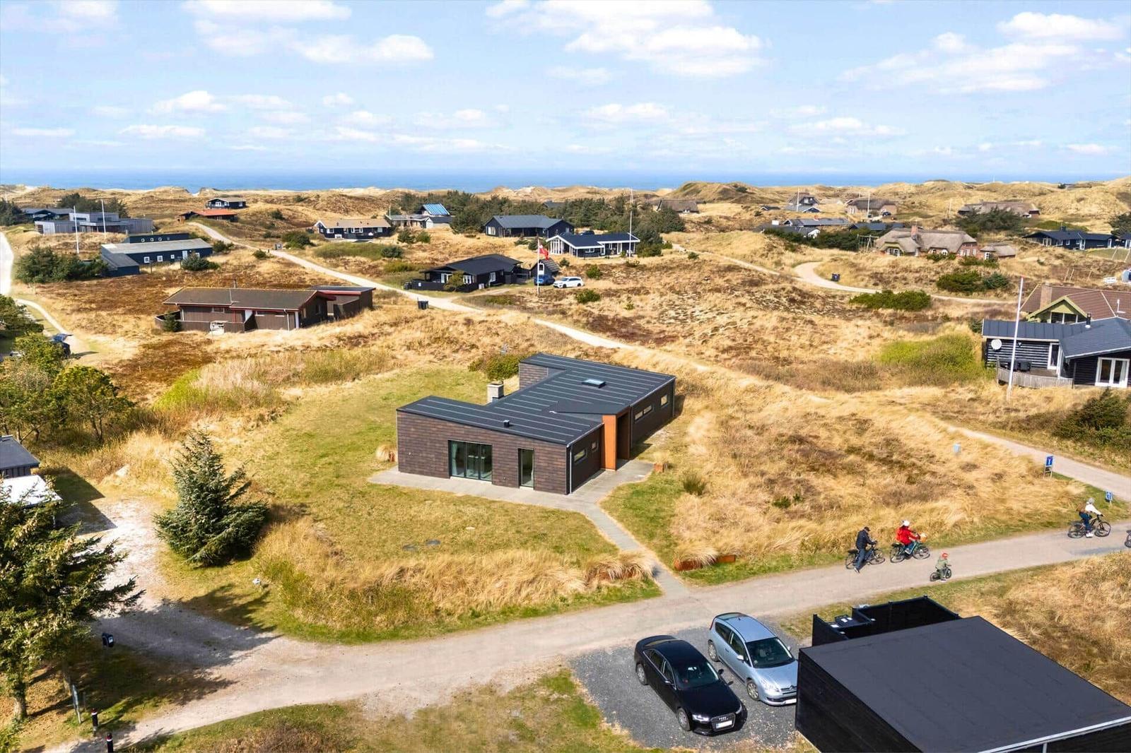 Modernes Haus mit großem Garten und Blick auf die Dünen und das Meer.