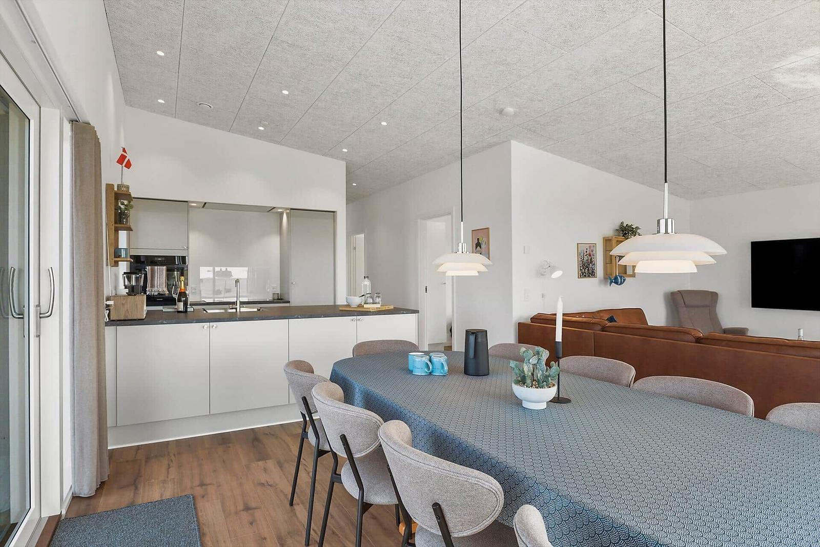 Moderne Küche mit Esstisch und Wohnbereich mit Sofa und Fernseher.