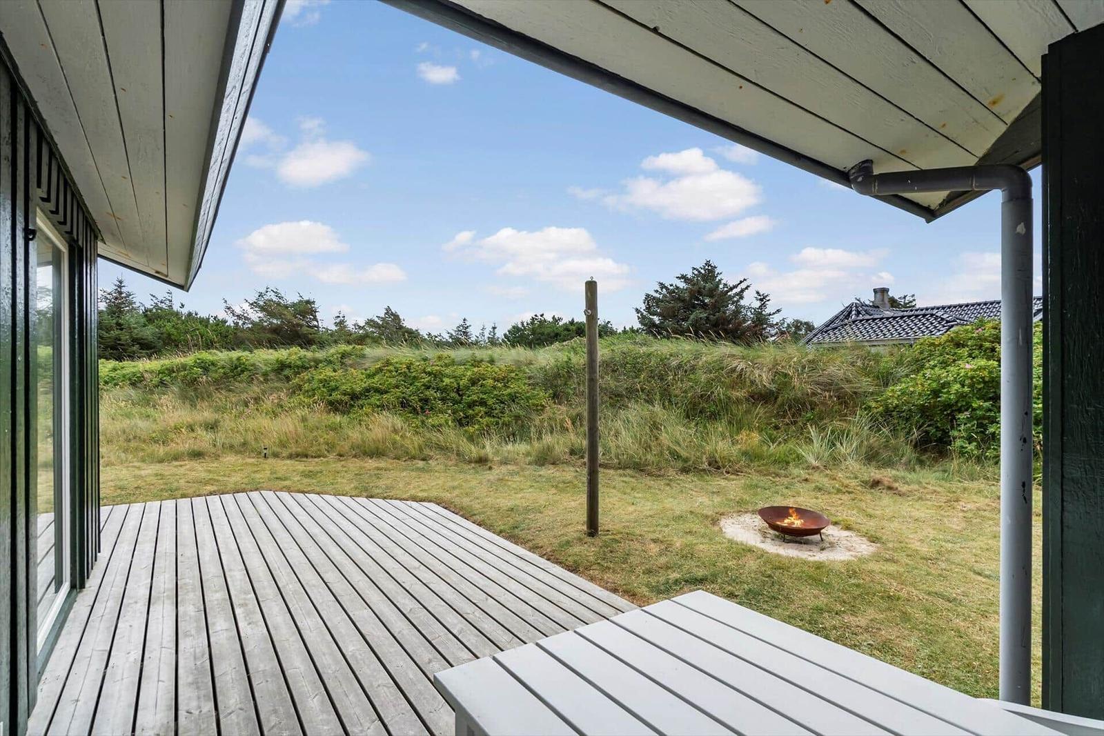Terrasse mit Sitzgelegenheit und Feuerkorb im Garten