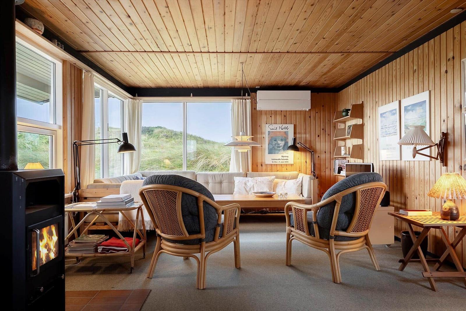 Wohnzimmer mit Holzwänden, Sitzgelegenheiten und Kamin