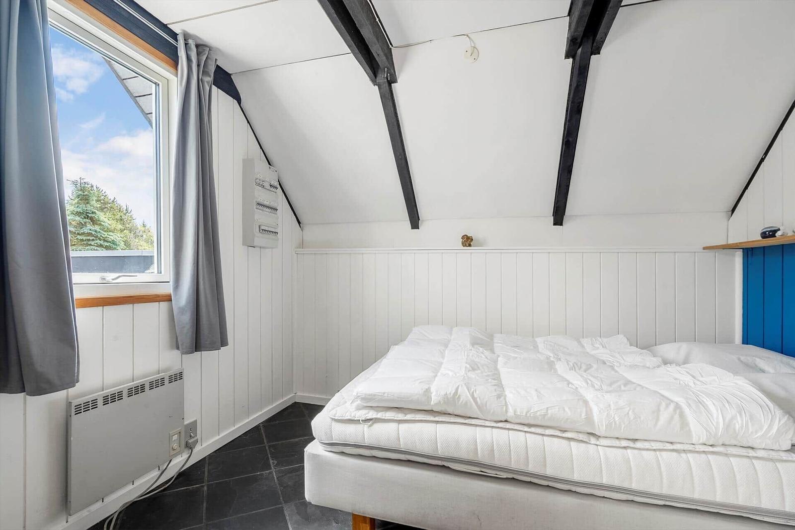 Bedroom with white bed, window and black floor
