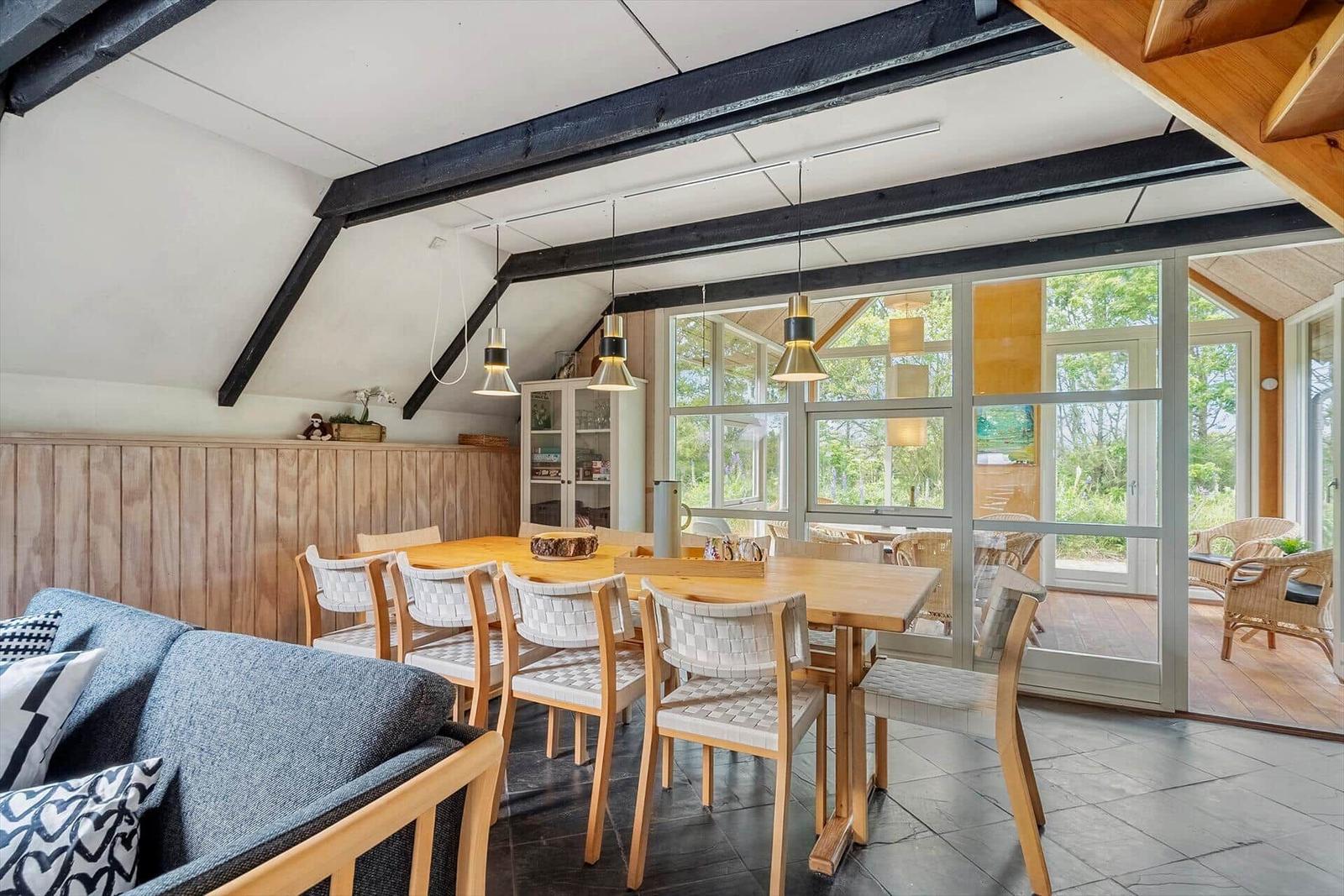 Dining area with wooden table, chairs, and view of terrace