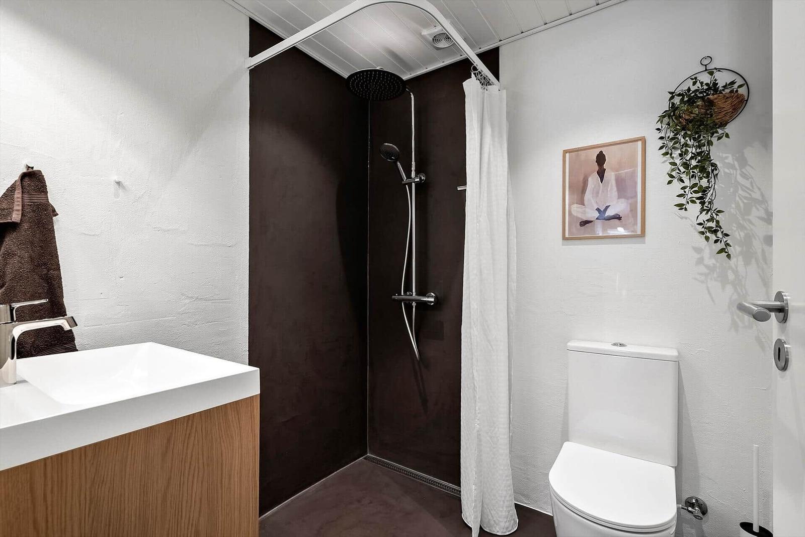 Badezimmer mit Dusche, Toilette und Waschbecken.