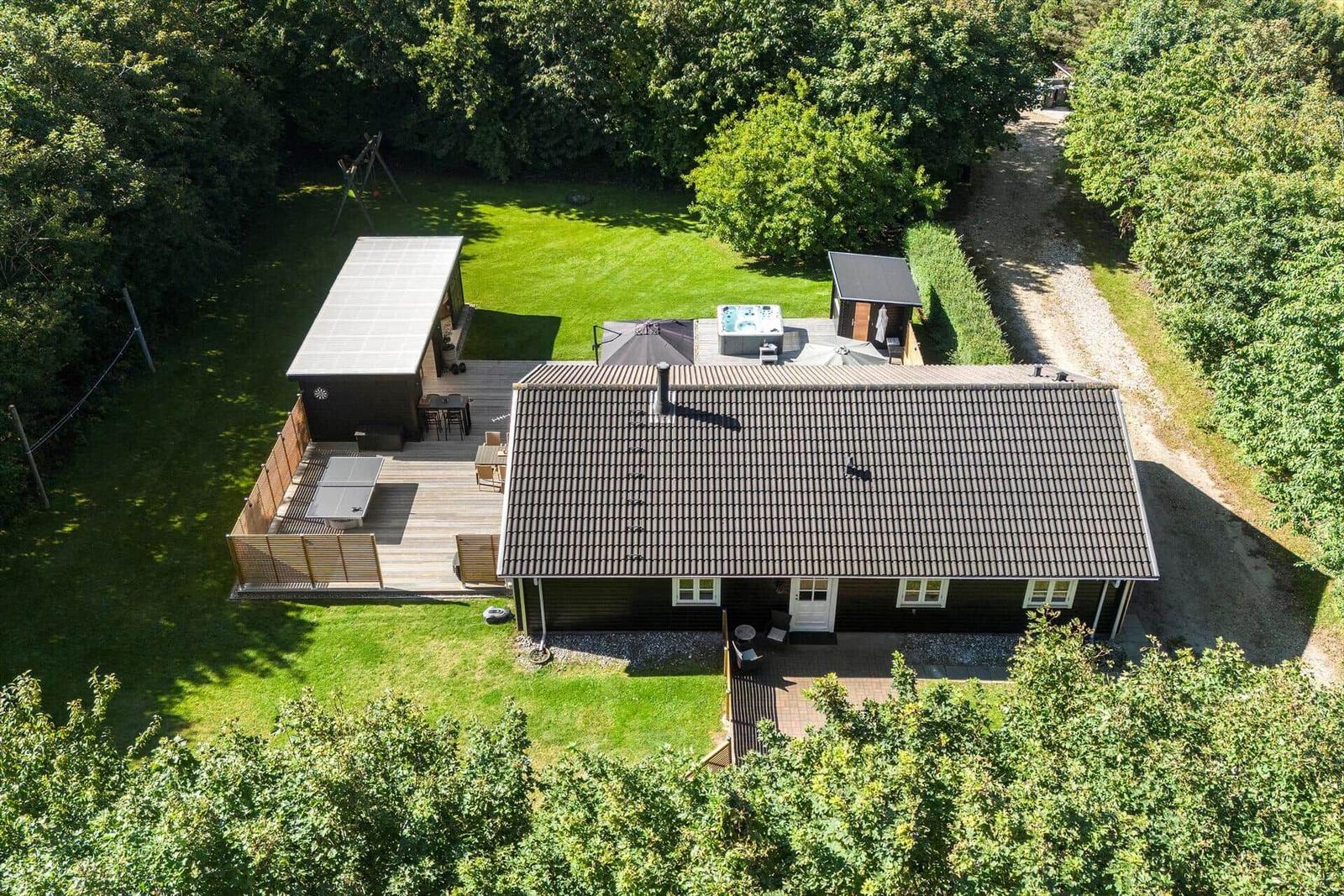 Haus mit Garten, Whirlpool und Terrasse in grüner Umgebung.