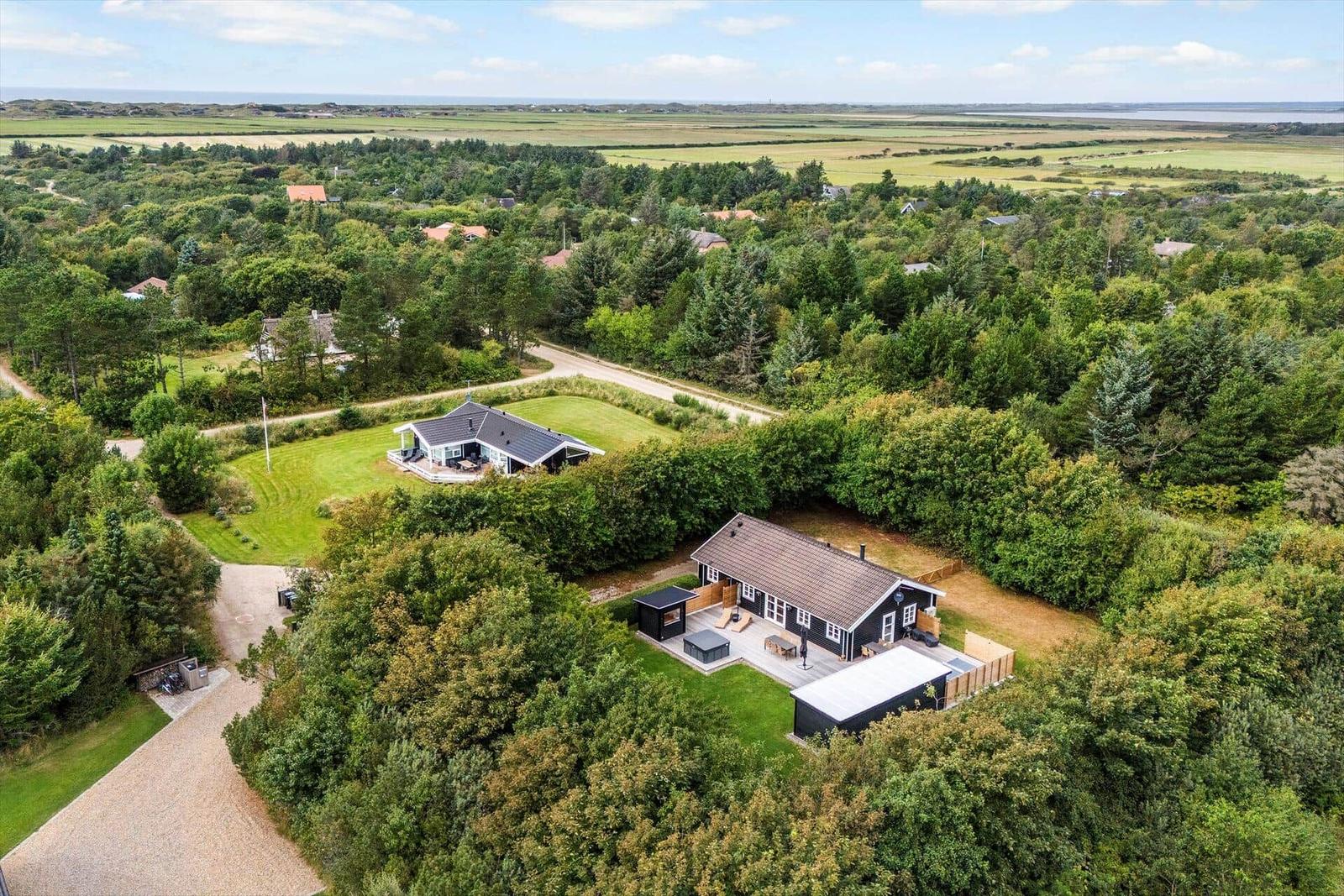 Haus mit Terrasse und Grillplatz in grüner Umgebung mit Blick auf die Landschaft.