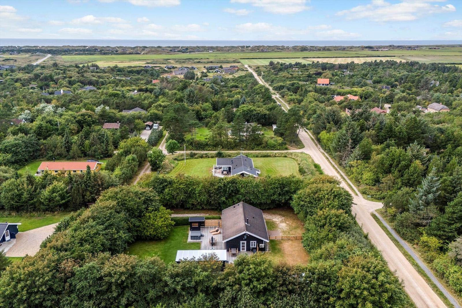 Haus mit Garten und Terrasse in grüner Umgebung mit Blick aufs Meer.
