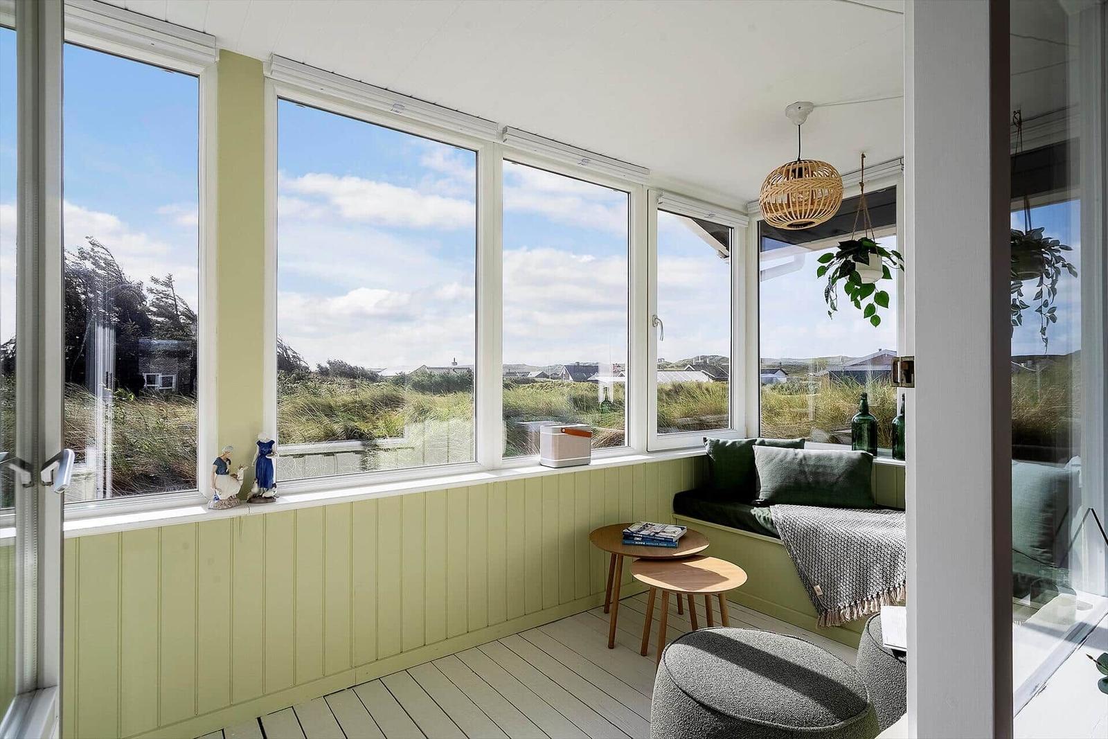 Sitzgelegenheit mit Blick auf die Landschaft durch große Fenster.