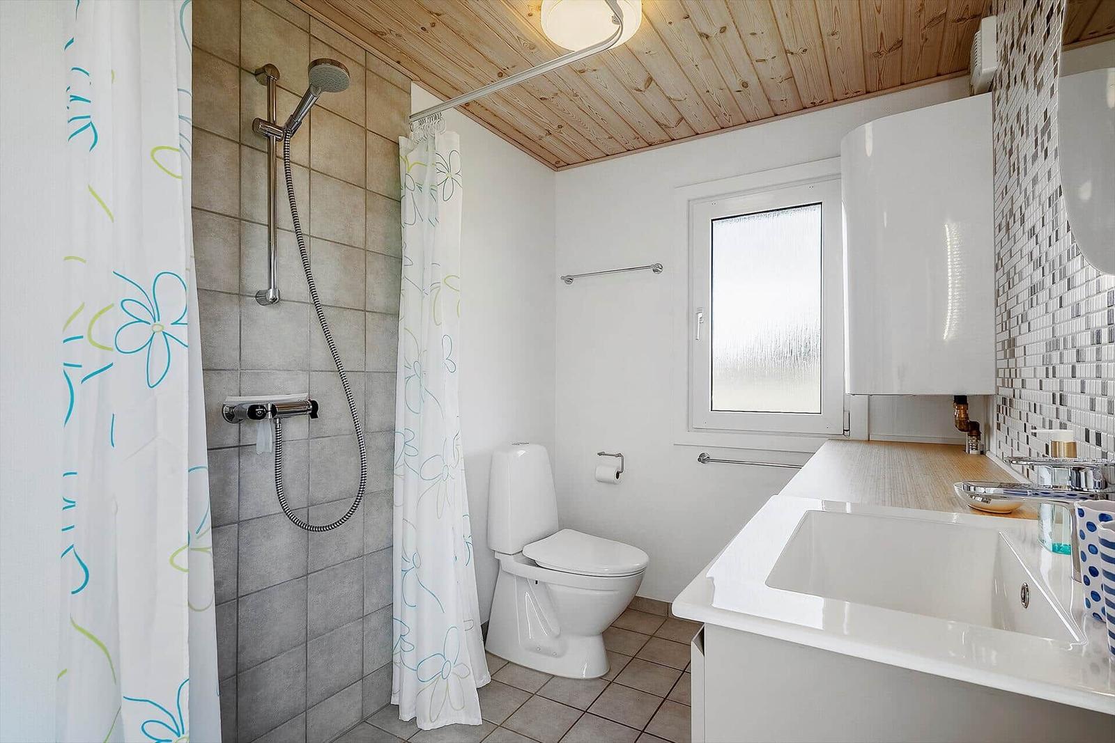 Badezimmer mit Dusche, Toilette und Waschbecken.