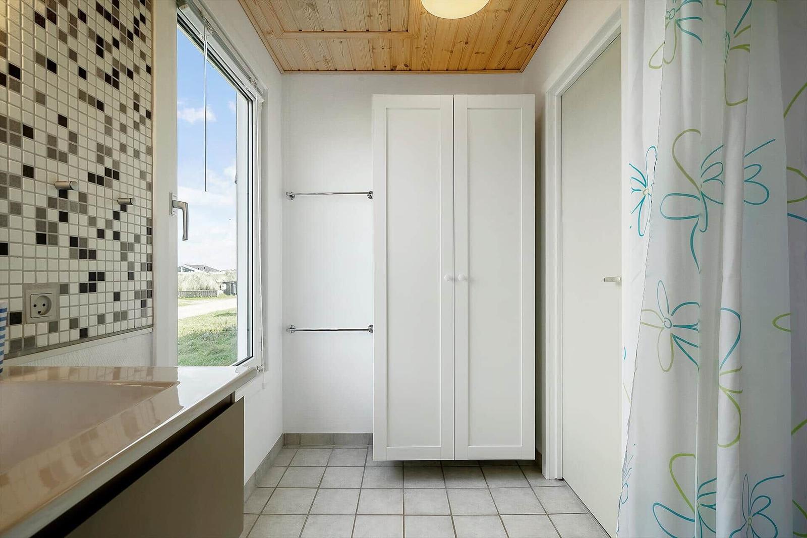 Badezimmer mit Dusche, Waschbecken und Fenster