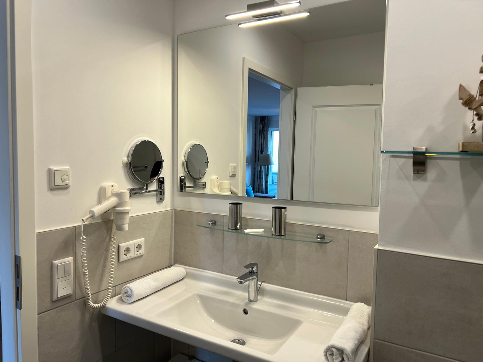 Badezimmer mit Waschbecken, Spiegel und Handtuch