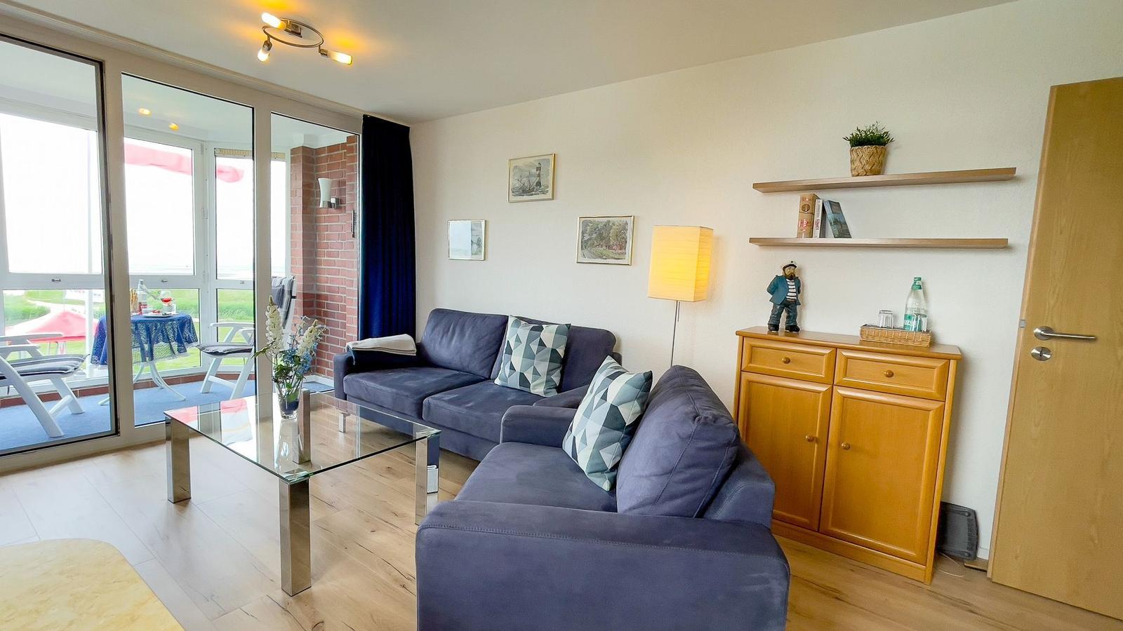 Living room with sofa, coffee table, and view of terrace.