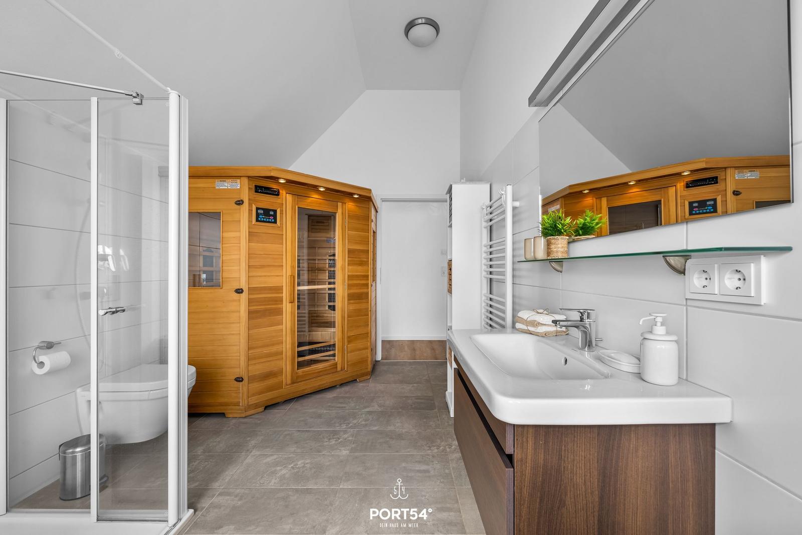 Badezimmer mit Dusche, Toilette und Sauna.