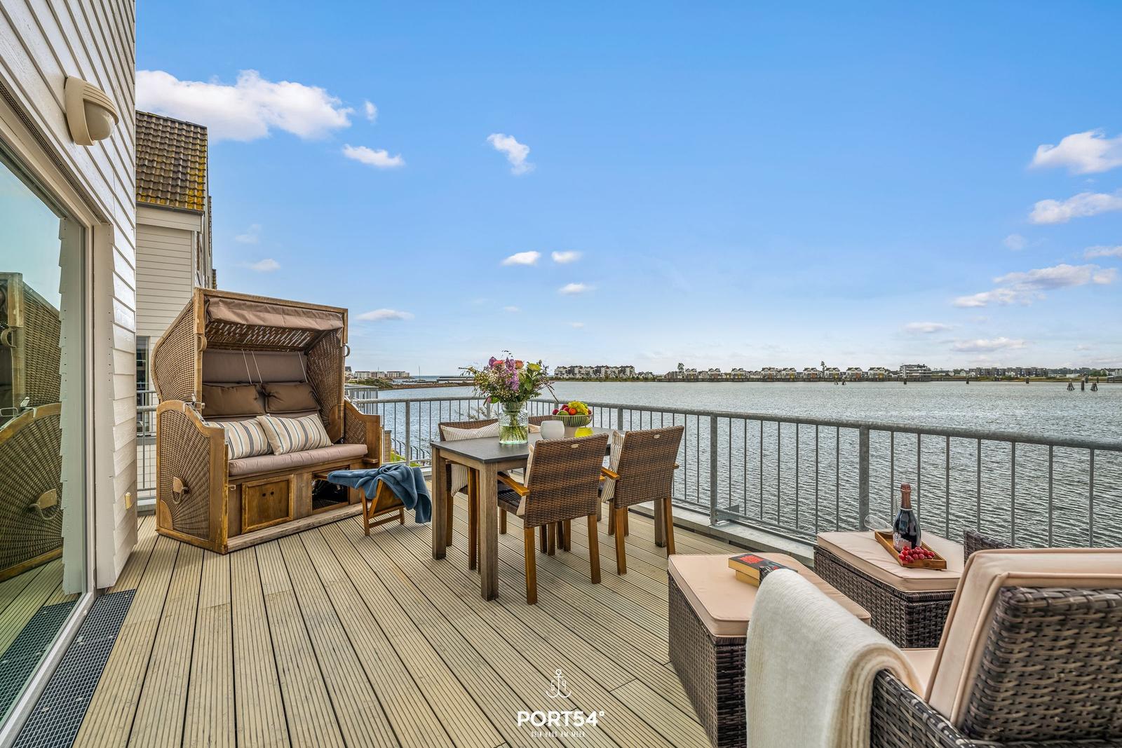 Terrasse mit Sitzgelegenheiten und Blick auf Wasser