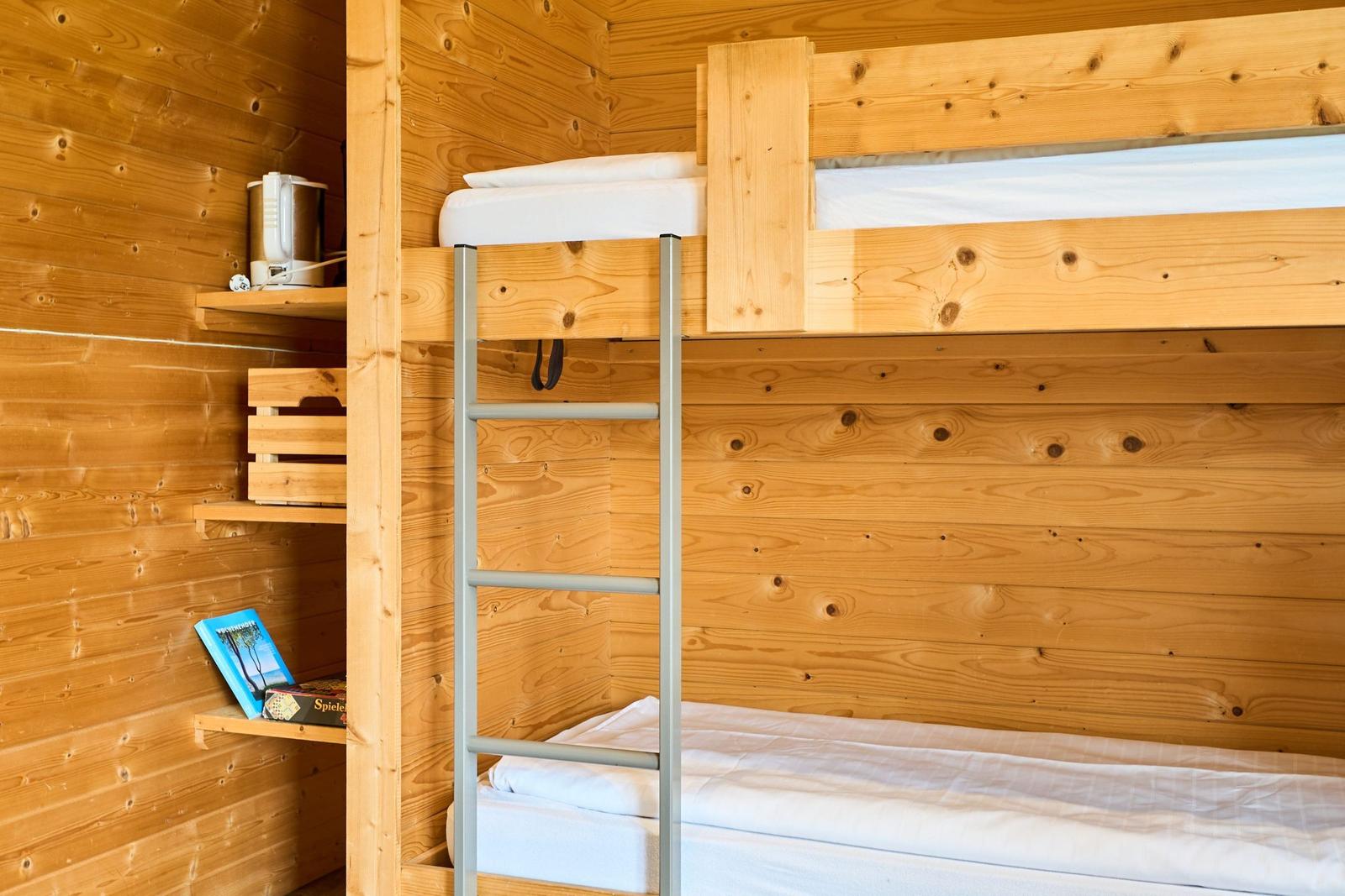 Doppelstockbett mit Kletterleiter und Holzwand im Schlafzimmer