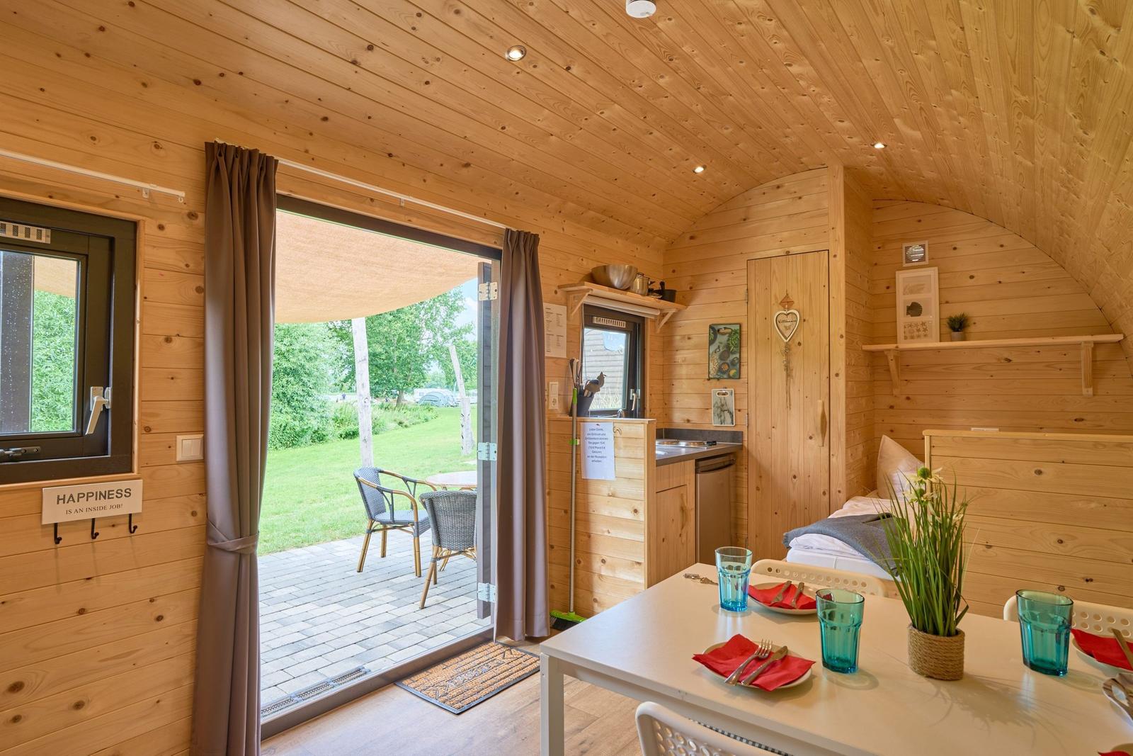 Holzhaus mit Schlafgelegenheit, Küchenzeile und Terrasse mit Gartenblick.