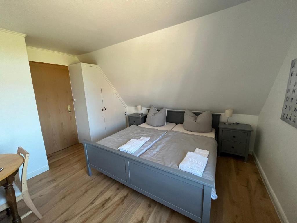 Schlafzimmer mit Doppelbett, zwei Nachttischen und Holzboden.