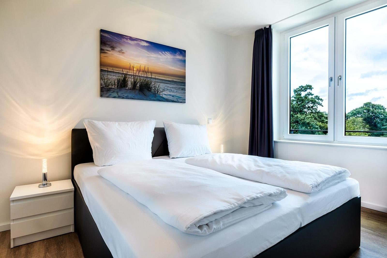 Schlafzimmer mit Doppelbett, Fenster und Wandbild