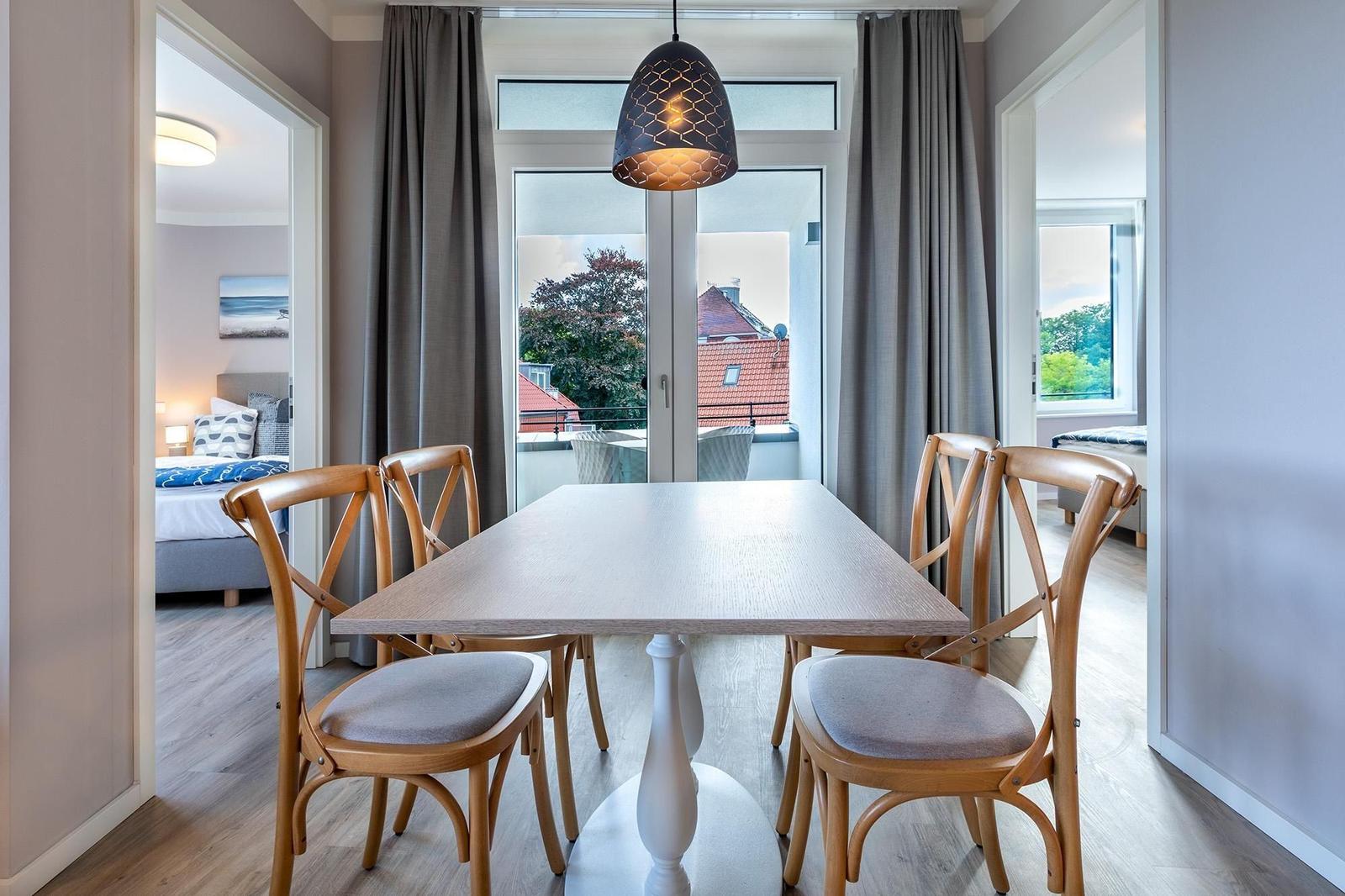 Essbereich mit Tisch und Stühlen, Blick auf Balkon und Zimmer