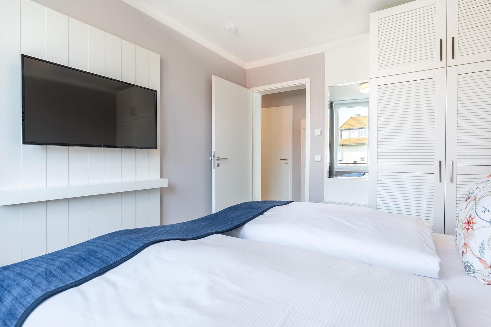 Schlafzimmer mit Bett, TV und Schrank