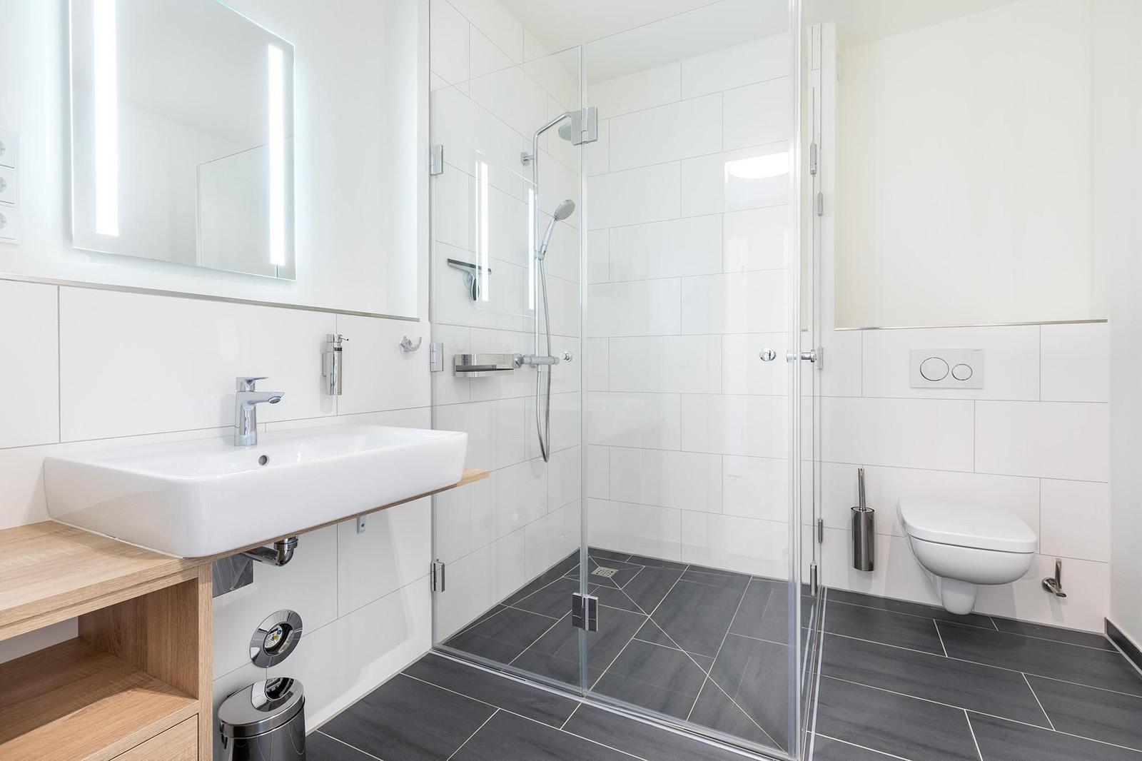 Badezimmer mit Dusche, Waschbecken und Toilette.