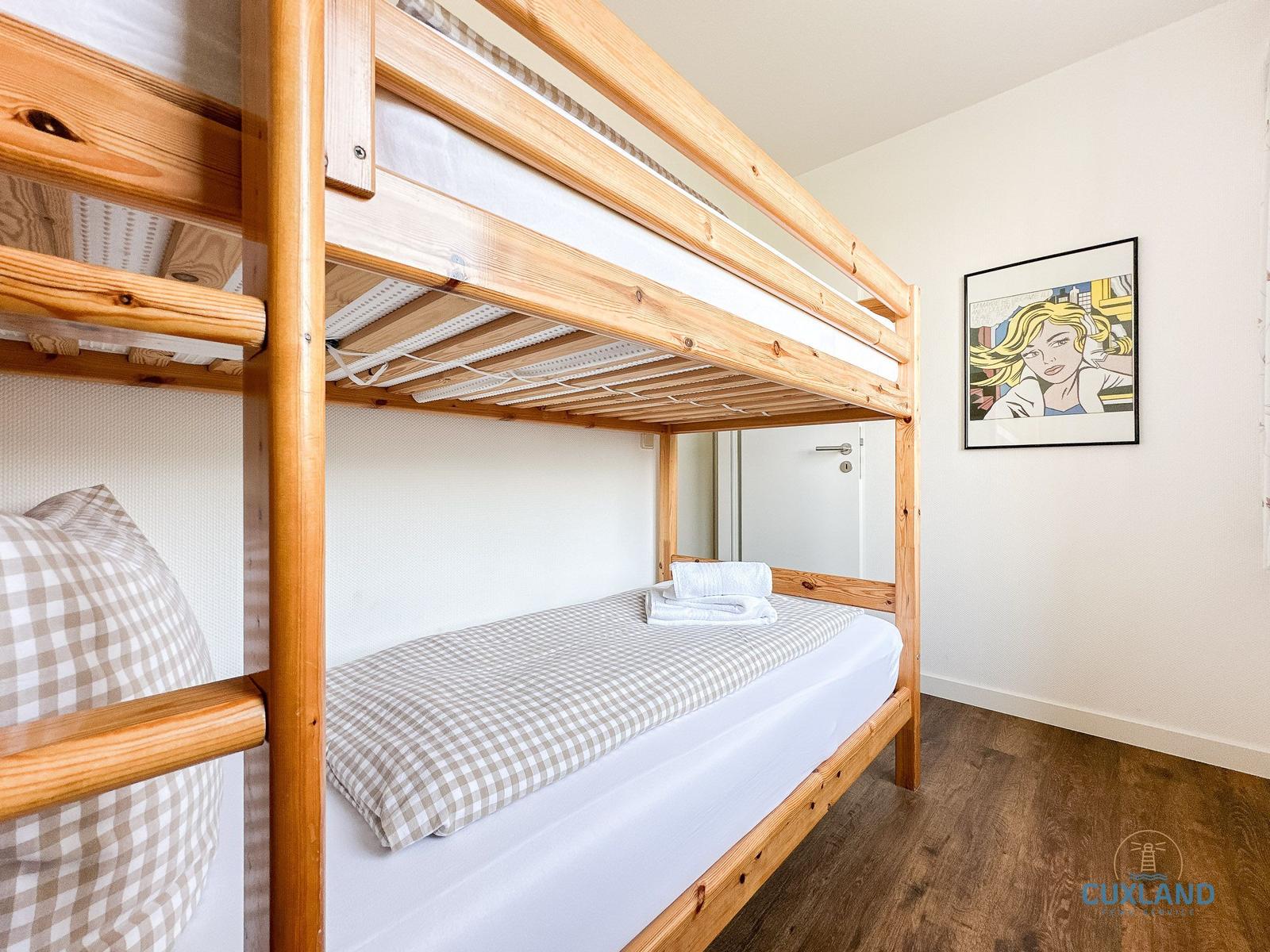 Ein Schlafzimmer mit einem Holzbett und einem Bild an der Wand.