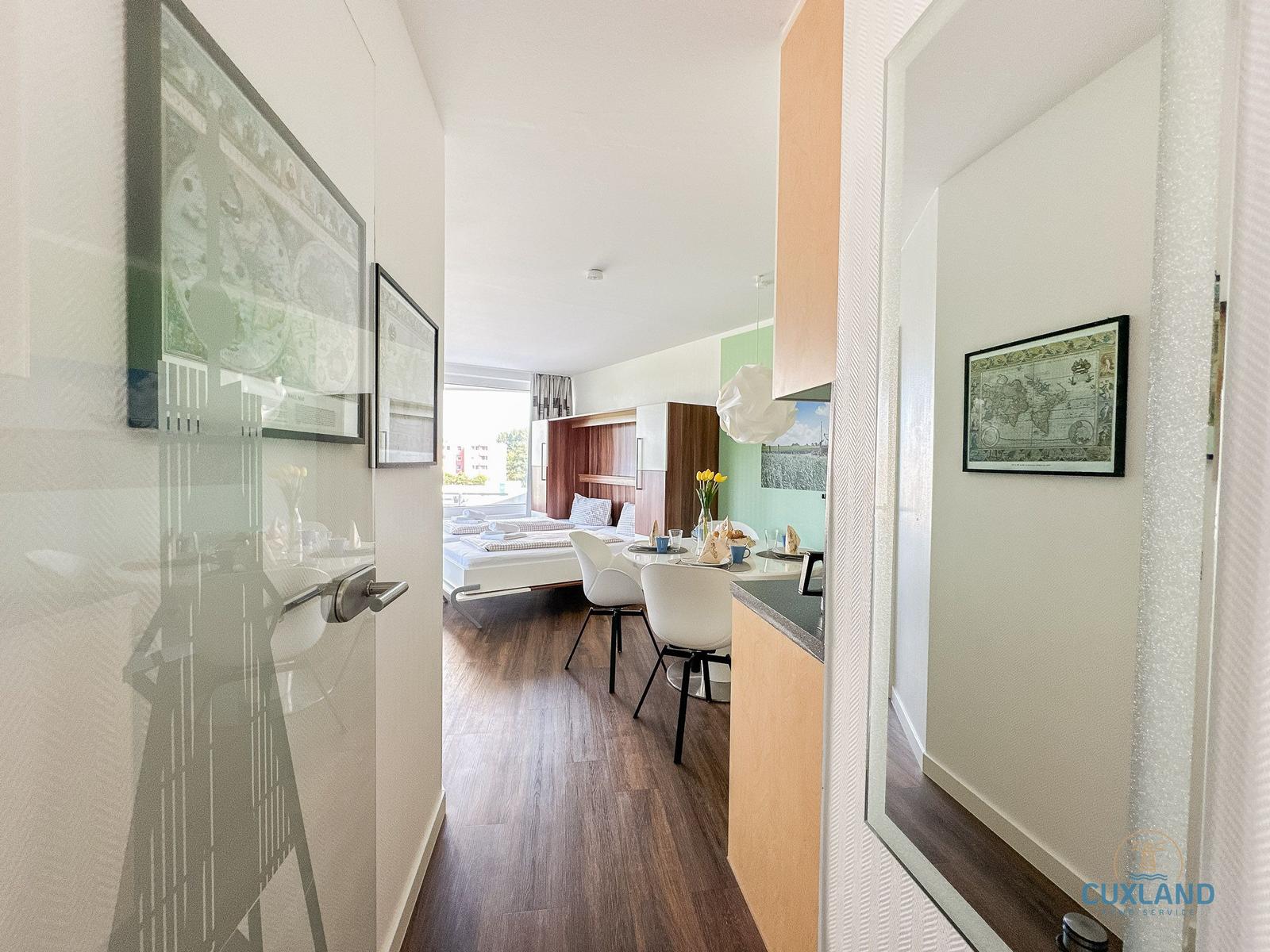 Wohnung mit Schlafzimmer, Essbereich und Küchenzeile.