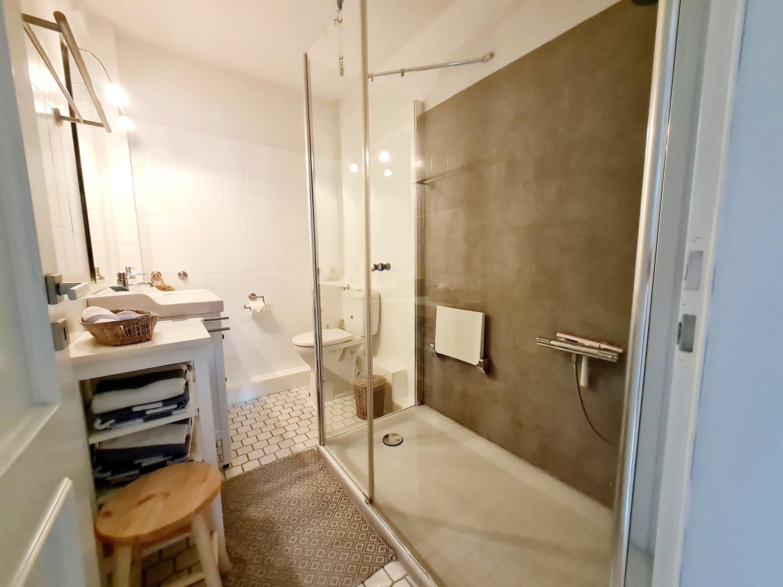 Badezimmer mit Dusche, Waschbecken und Toilette.