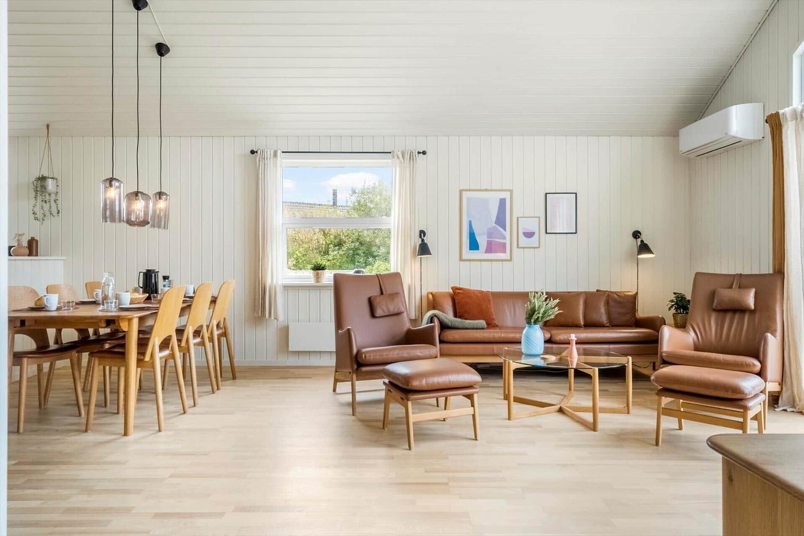 Wohn- und Essbereich mit braunen Ledermöbeln und Holzmöbeln.