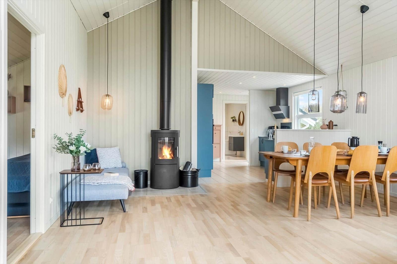 Wohn- und Essbereich mit Kamin, Holzboden und Essgruppe.