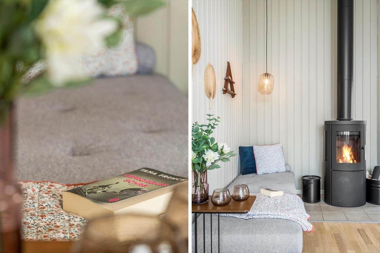 Ein Wohnbereich mit Sofa, Kamin und Tisch mit Blumen.