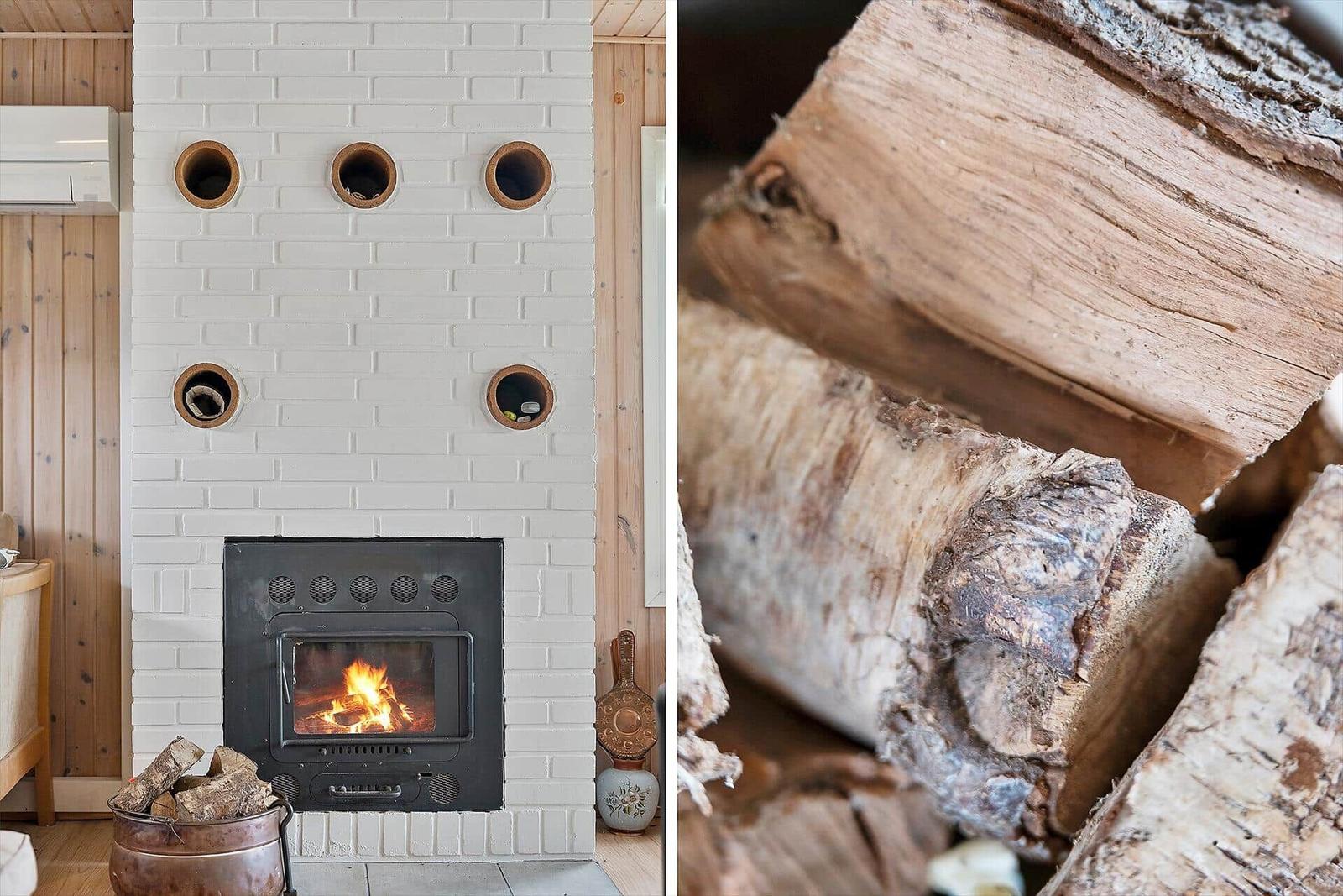 Kamin mit Brennholz und weißen Ziegelwänden. Holzscheite für den Kamin.