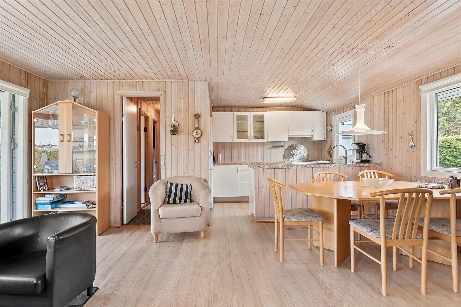Küche mit Essbereich und Sitzgelegenheiten in Holzhaus