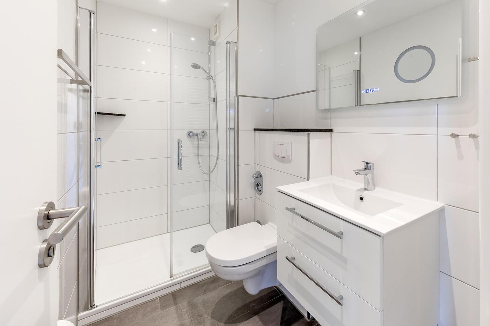 Badezimmer mit Dusche, Toilette und Waschbecken.