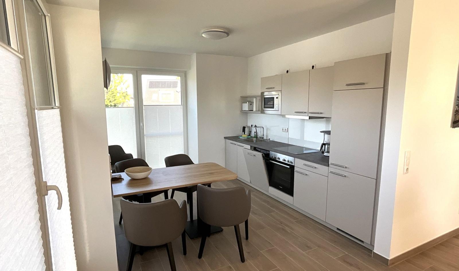 Küche mit Essbereich und Balkontür. Moderne Einbauküche mit Küchenschränken.