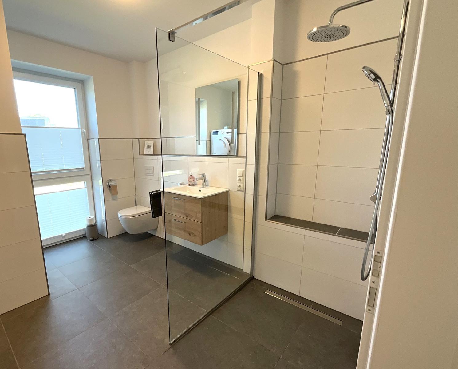 Moderne Badezimmer mit Dusche, Waschbecken und Toilette.