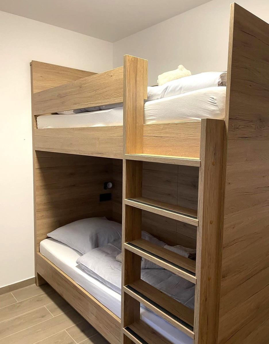 Holz-Etagenbett mit Schlafcouch und integriertem Treppenaufgang.