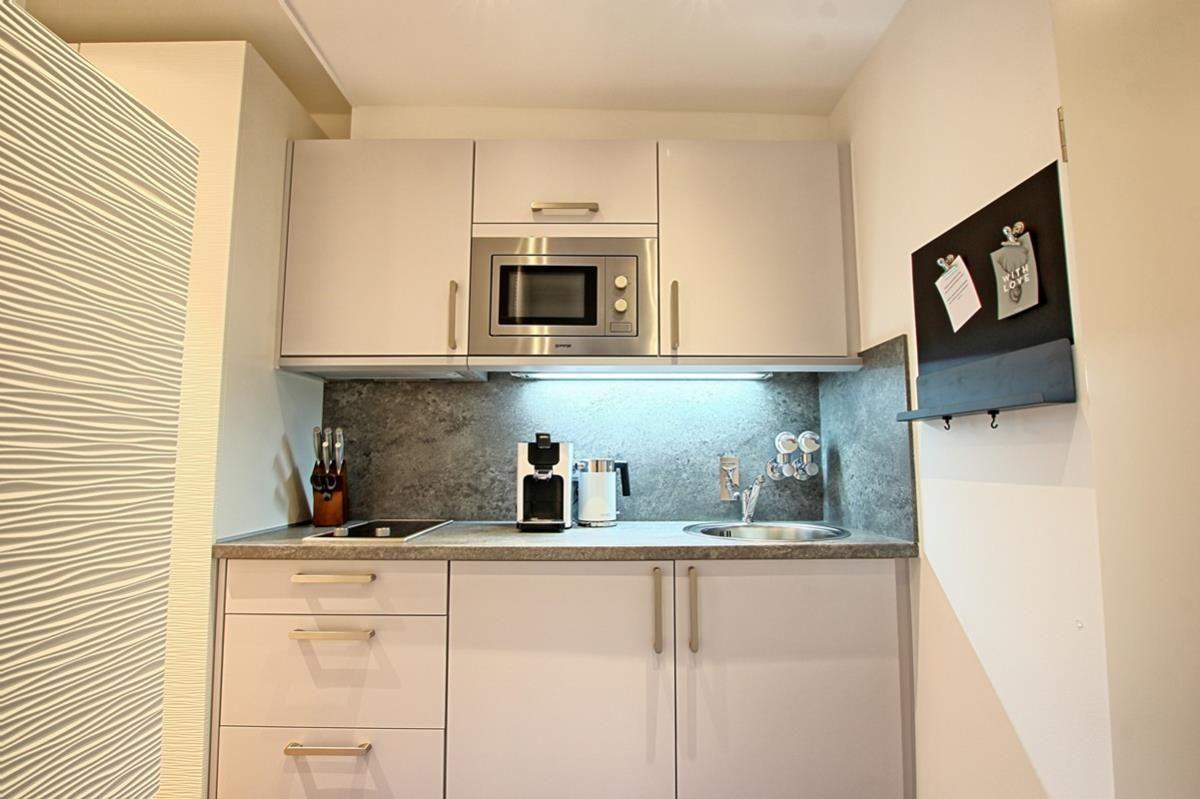 Küche mit Mikrowelle, Spüle und Küchenzeile